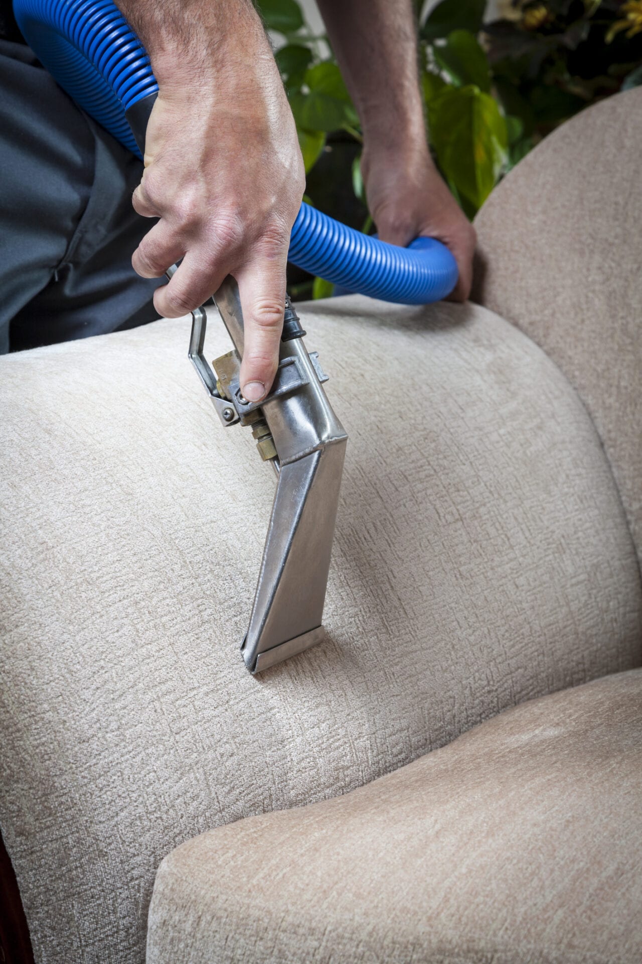 Man cleaning sofa  with steam cleaning in home